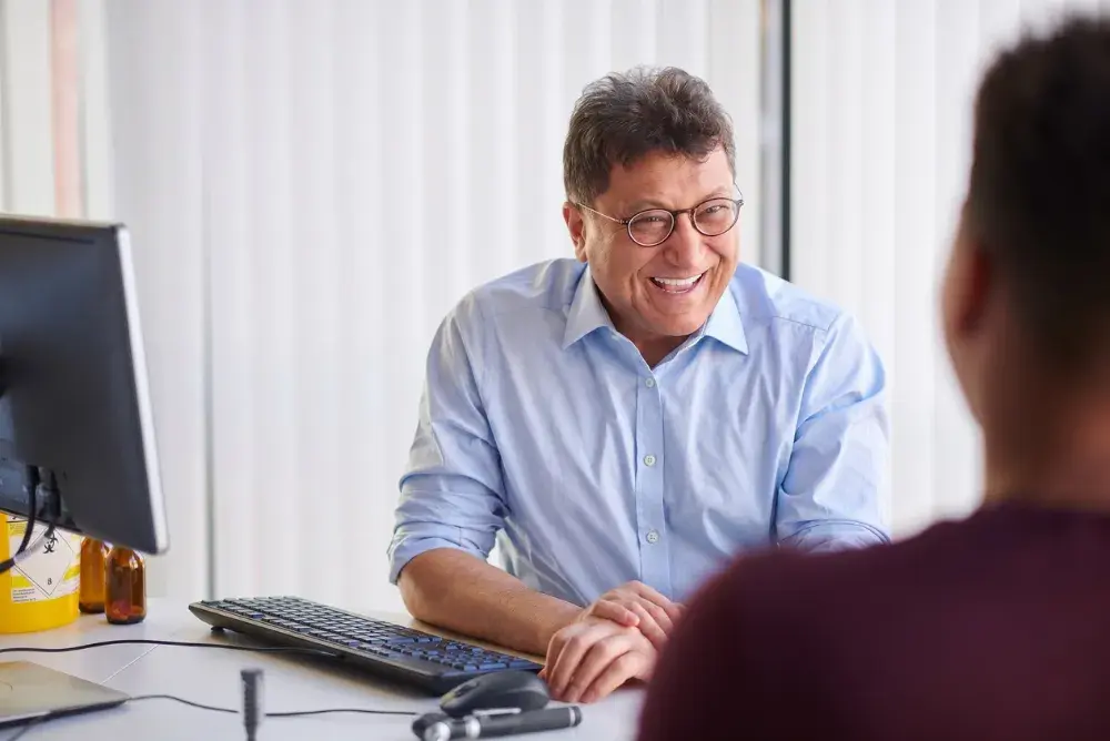 a GP sits across the desk from a patient