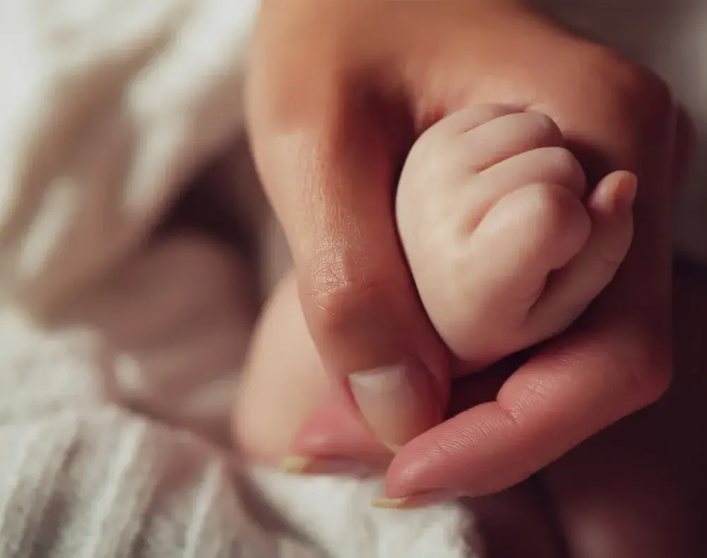 a close up of a mum and baby hand
