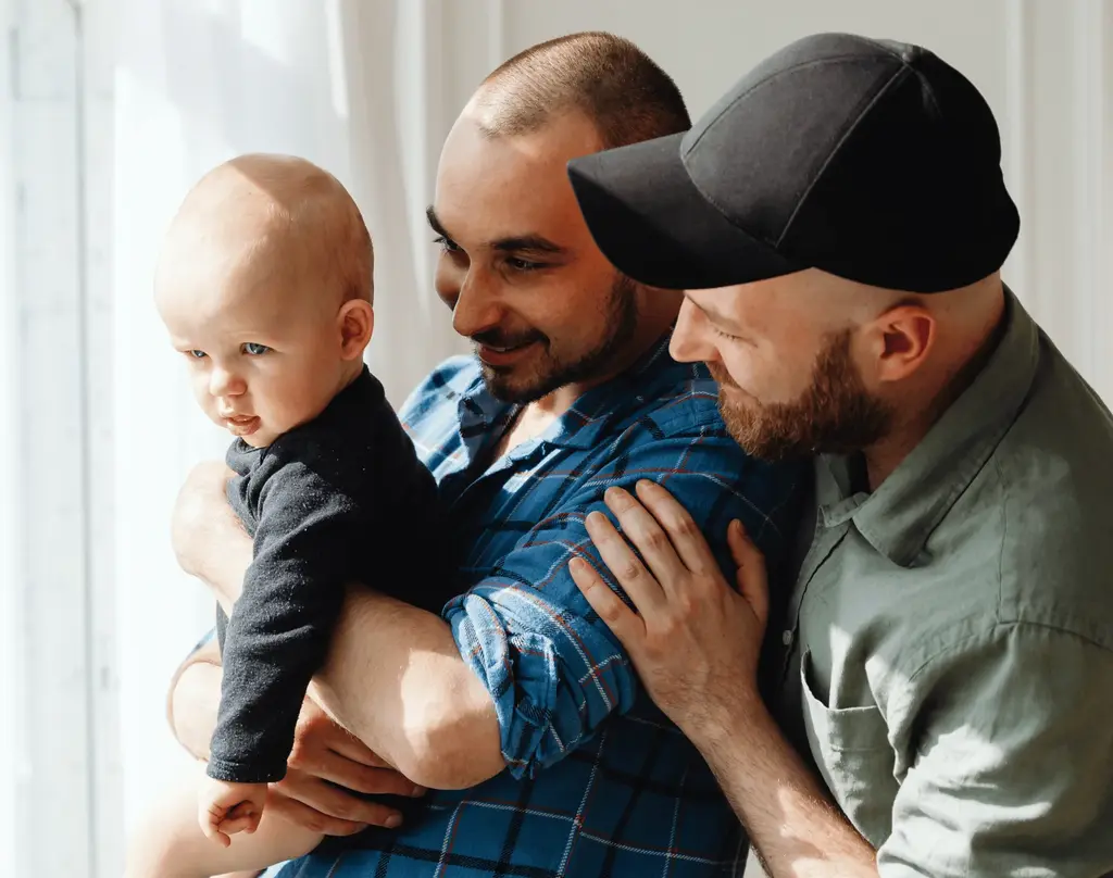Two dads support their baby son