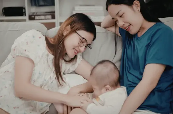 Two mums looking after their baby